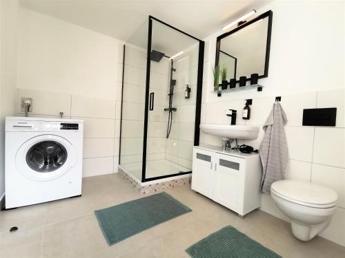 a bathroom with a toilet sink and a washing machine at BohnApartments Suite Am Markt - Vollausstattung - WLAN - Zentrum in Ilmenau