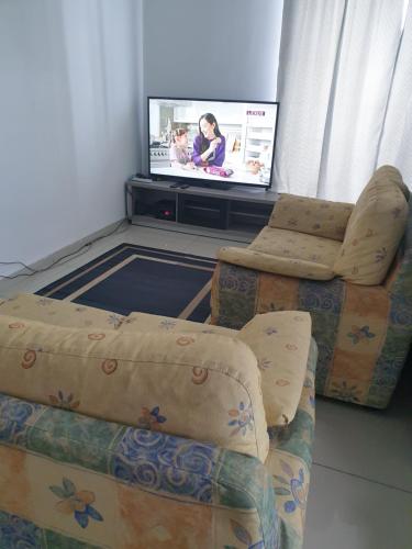 sala de estar con sofá y TV de pantalla plana en I-City Shah Alam Homestay, Studio, 2 Katil Queen, 1 Sofa, Balcony, en Kampong Padang Jawa