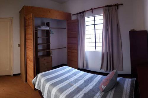 Habitación con terraza privada في مدينة ميكسيكو: غرفة نوم بسرير ونافذة
