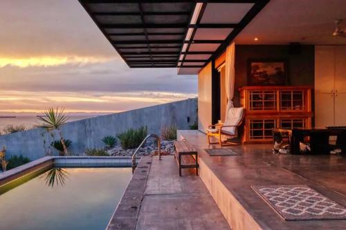 a house with a swimming pool with a view of the ocean at Villa Wellmina - Stunning Sunsets & Relaxing Poolside Vibes! in La Paz