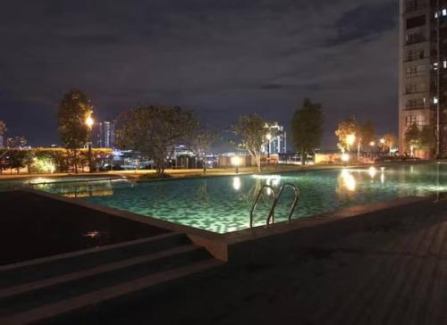 una gran piscina por la noche con luces en HA1605- 2 BEDROOM- WI-FI-NETFLIX-PARKING- CYBERJAYa, 3077, en Cyberjaya