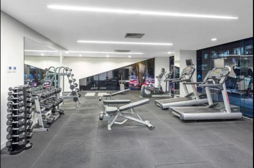 a gym with treadmills and machines in a room at Aura2107, CBD Entire 2 Bedroom Apartment with Balcony and Stunning Yarra River Views in Melbourne