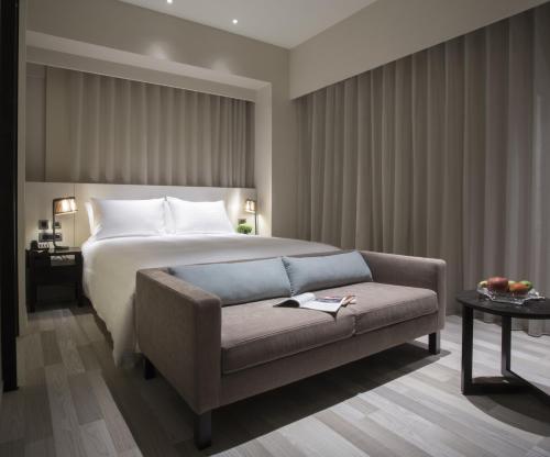 a hotel room with a bed and a couch at Riverview Suites Taipei in Taipei