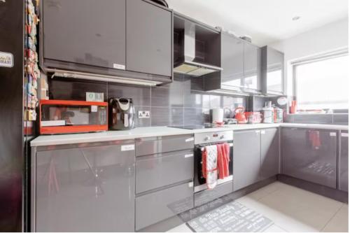 a kitchen with stainless steel cabinets and appliances at Wonderful Family Friendly Cosy Home Free Parking in Crayford