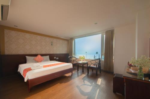 een slaapkamer met een groot bed en een groot raam bij LE SOLEIL HOTEL managed by NEST Group in Nha Trang