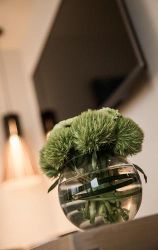 a vase filled with green flowers on a table at Riverview Suites Taipei in Taipei