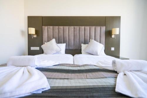 two beds in a hotel room with white sheets and pillows at Napa Jay Hotel in Ayia Napa