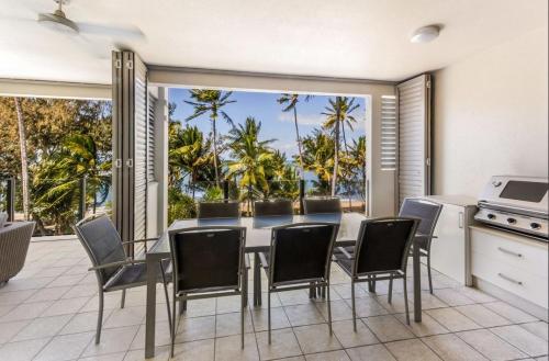 a kitchen and dining room with a table and chairs at Island Views Beachfront Apartments in Palm Cove
