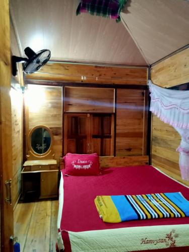 a bedroom with a bed in a room with a tv at Linh Homestay and motorbikes rent in Ha Giang