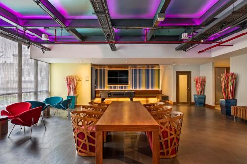 a dining room with a table and chairs and a piano at Aloft Bangkok - Sukhumvit 11 in Bangkok