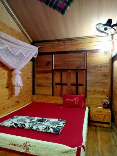 a bedroom with a bed with a red blanket at Linh Homestay and motorbikes rent in Ha Giang
