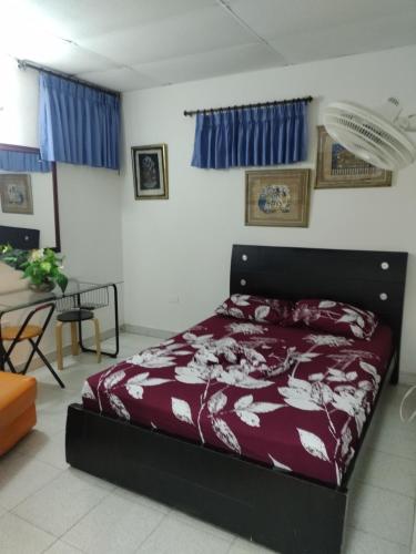 a bedroom with a bed in a room with blue curtains at Apartamentos Arriendo Rodadero in Santa Marta