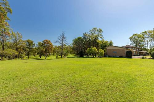 a large green field with a building in the background at Cundletown Cove in Cundletown