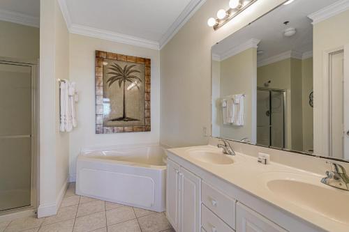 La salle de bains est pourvue d'un lavabo, d'une baignoire et d'un miroir. dans l'établissement Pavilion Watch #3I, à Folly Beach