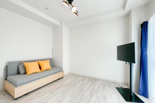 a living room with a couch and a tv at Osaka house honkan なんば-心斎橋エリア in Osaka