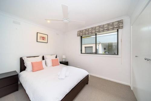 a white bedroom with a bed and a window at Spacious 3Bd n Pool family holiday home TF2223 in Frankston