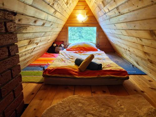 een kleine kamer met een bed in een blokhut bij Bezgova Hišica in Bovec