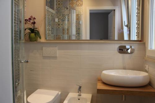 a bathroom with a sink and a toilet and a mirror at Aurora BnB in Pisa