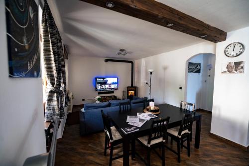 a living room with a table and a blue couch at CASA ZAN arte & outdoor verso la Valle d'Aosta in Baio Dora