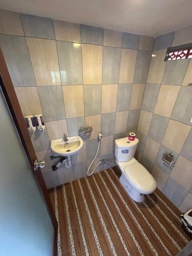a bathroom with a toilet and a sink at Puri Sundaram Villa in Ubud