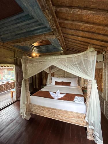 um quarto com uma cama de dossel em Puri Sundaram Villa em Ubud