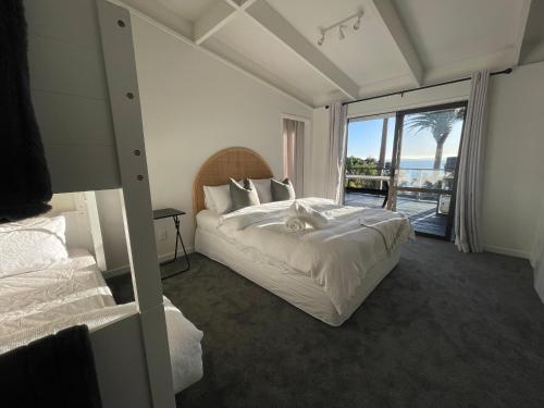 a hotel room with a bed and a view of the ocean at Private Water Front House in Whangaparaoa