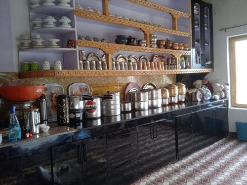 uma cozinha com um balcão com panelas e frigideiras em Nubra Holiday em Deskit