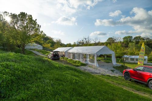 a red car parked next to a tent on a field at Gala park fpv in Avren