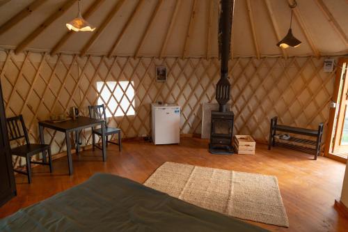 a room with a stove and a table in a yurt at Gala park fpv in Avren