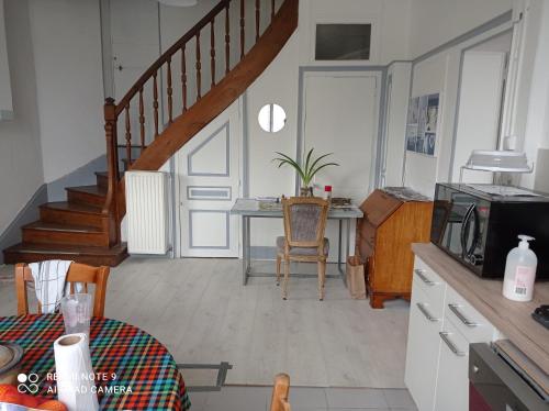une cuisine avec un escalier et une table avec une table dans l'établissement Au calme, 2 grandes chambres, 65m2 , devant le canal, animaux ok, à Lere