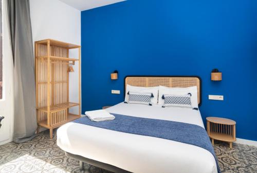 een blauwe slaapkamer met een bed met een blauwe muur bij Caliu Apartments Barcelona in Hospitalet de Llobregat