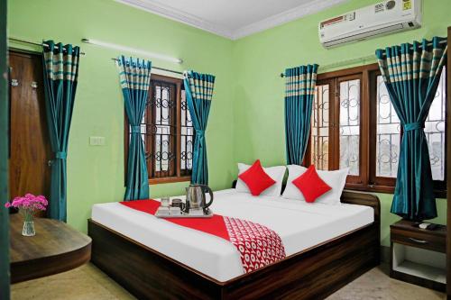 um quarto com uma cama com cortinas vermelhas e azuis em Flagship Himgiri Guest House em Calcutá