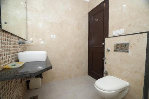 a bathroom with a toilet and a sink and a mirror at Hotel Silver Arc - Karol Bagh New Delhi in New Delhi