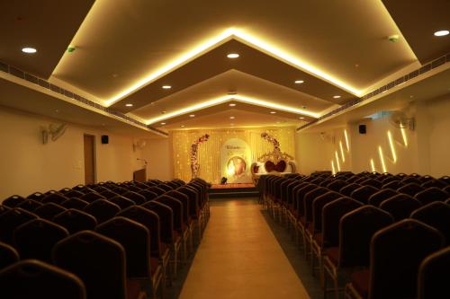 an empty auditorium with black chairs and a stage at HOTEL CHALLIYIL CASTLE in Shertallai