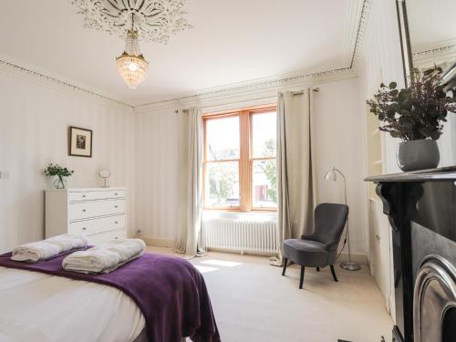 a bedroom with a bed and a chair and a window at Mary Ann Villa in Inverness