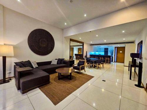 un ampio soggiorno con divano e tavolo di Beachfront 2 BR Luxury Apartment Chava Surin a Surin Beach