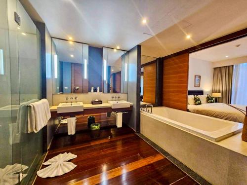 un bagno con due lavandini, una vasca e un letto di Beachfront 2 BR Luxury Apartment Chava Surin a Surin Beach