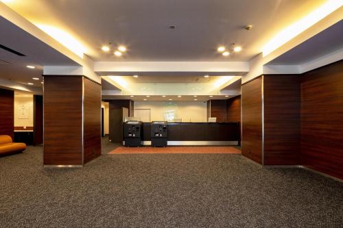 eine leere Lobby mit Holzvertäfelungen und ein großes Zimmer in der Unterkunft Kumamoto Tokyu REI Hotel in Kumamoto