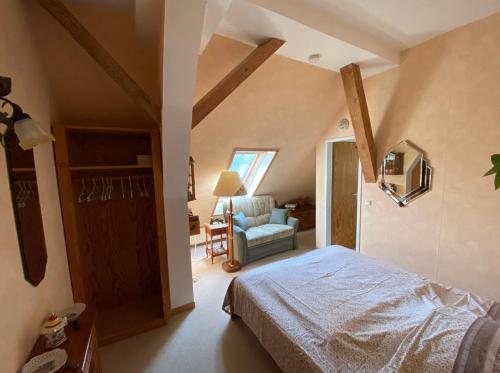 een slaapkamer met een bed en een stoel in een kamer bij KULTURGUTLEBEN Boutiquehotel Seminarhaus in Möllenbeck