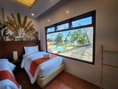 sypialnia z łóżkiem i dużym oknem w obiekcie Costa Celine Beach Resort w mieście Kinablañgan
