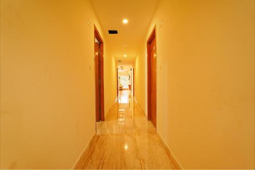 an empty hallway with yellow walls and wooden floors at FabHotel Shakthi Suites - Nr Jayadeva Hospital in Bengaluru