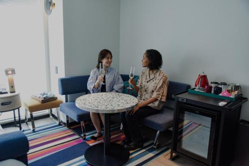 two women sitting at a table talking on microphones at Aloft Osaka Dojima in Osaka