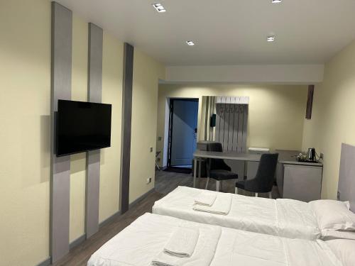 a bedroom with two beds and a flat screen tv at Kapriz Issyk Kul Resort in Cholpon-Ata