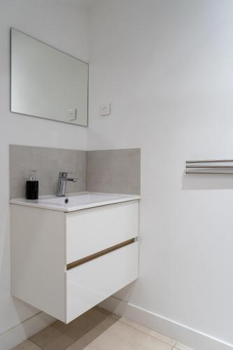 - une cuisine blanche avec un évier et un mur dans l'établissement Esprit Loft & Club proche embarcadère Corse Mayol Port Centre historique, à Toulon