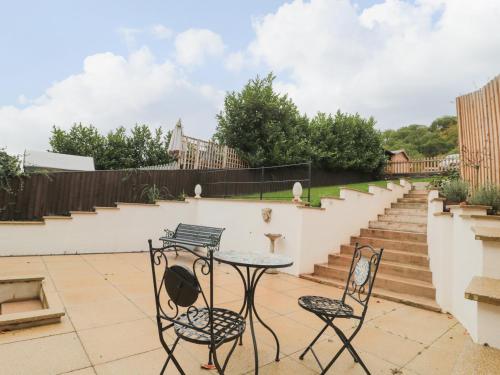 a table and chairs on a patio with stairs at Celia's View in Langport