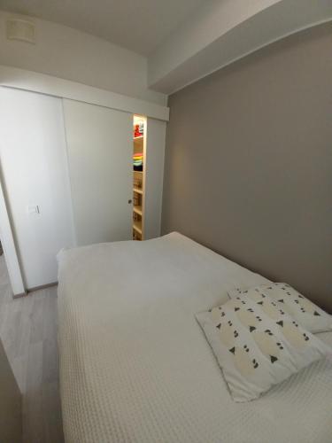 a bedroom with a white bed with a pillow on it at Haapala in Rovaniemi