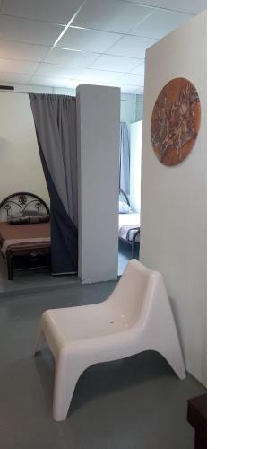 a white bench in a room with a bed at Langkawi-Village Mix Dormitory in Pantai Cenang