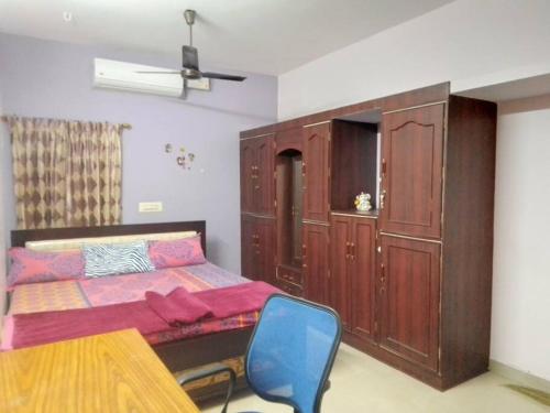 a bedroom with a bed and a blue chair at Aathira's 2 Bedroom house @ Heart of Coimbatore in Coimbatore