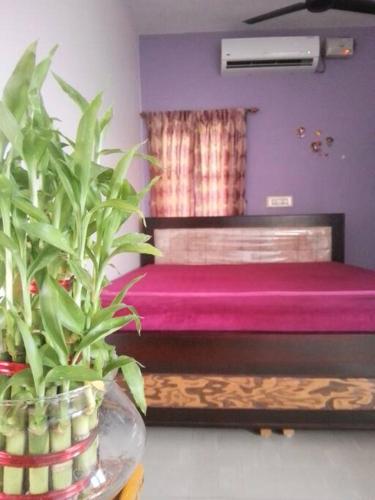 a bedroom with a pink bed and a potted plant at Aathira's 2 Bedroom house @ Heart of Coimbatore in Coimbatore