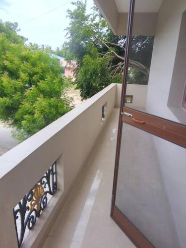 a balcony with a view of a street and trees at Aathira's 2 Bedroom house @ Heart of Coimbatore in Coimbatore